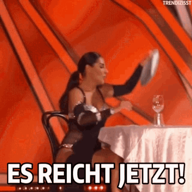 a woman sitting at a table with a plate in her hand and the words es reicht jetzt