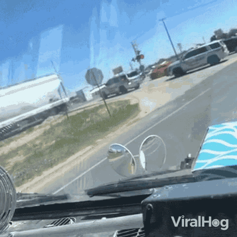 a car is driving down a road and the word viralhog is on the dashboard