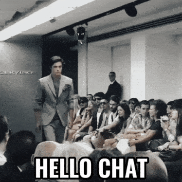 a man in a suit walks down the runway at a fashion show with the words hello chat below him
