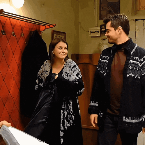 a man and woman are standing next to each other in a room