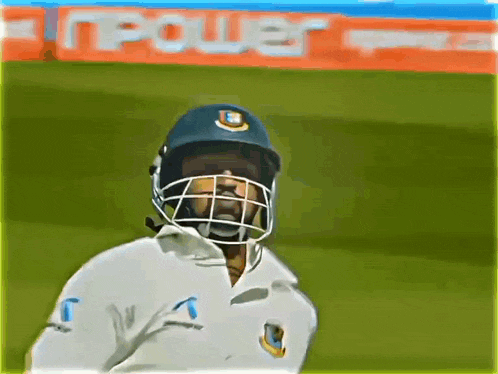 a cricket player wearing a helmet with the letter b on it stands on a field