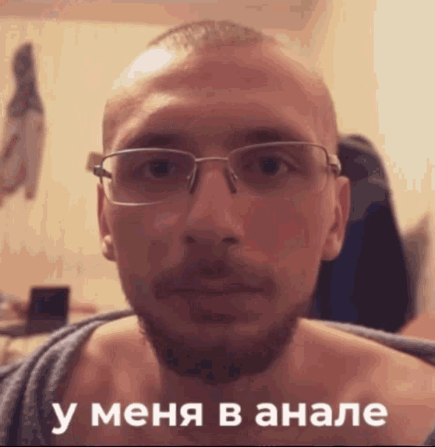 a man with glasses and a beard looks at the camera with a caption in russian that says " у меня в анале "