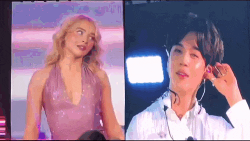 a man and a woman are standing next to each other on a stage . the woman is wearing a purple dress .