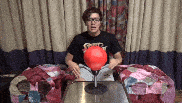 a man wearing a shirt that says street fighter is sitting in front of a punching bag