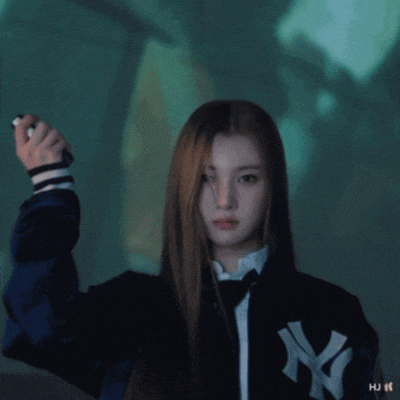 a woman wearing a ny yankees jacket is holding a pen