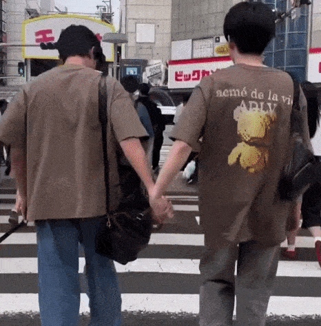a man wearing a shirt that says neme de la vi is holding a woman 's hand