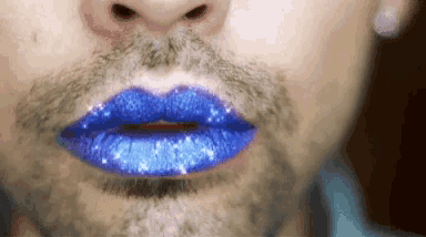 a close up of a man 's face with blue lipstick and a beard