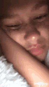 a close up of a person 's face with a hand on their face .