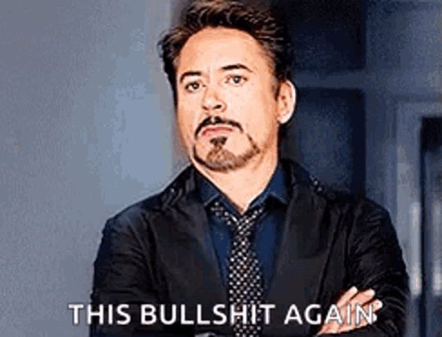 a man in a suit and tie is standing with his arms crossed and saying this bullshit again .
