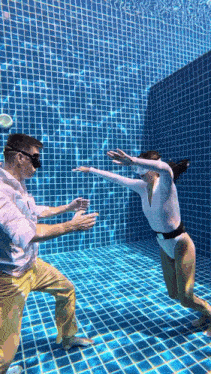 a man and a woman are underwater in a swimming pool .