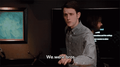 a man in a plaid shirt says " we were bros " in front of a television
