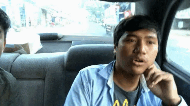a man sitting in the back seat of a car wearing a shirt that says aa