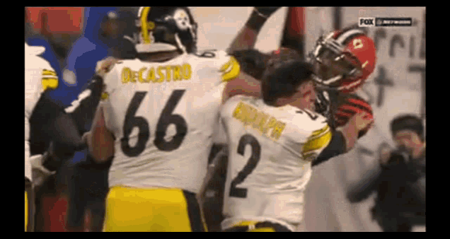 a football player with the number 66 on his jersey is being tackled by another player