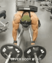 a man is laying on a bench in a gym holding a barbell on his back .