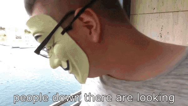 a man wearing glasses and a green mask with the words people down there are looking below him