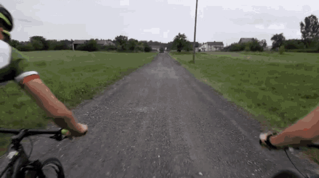 a person is riding a bike down a dirt road .