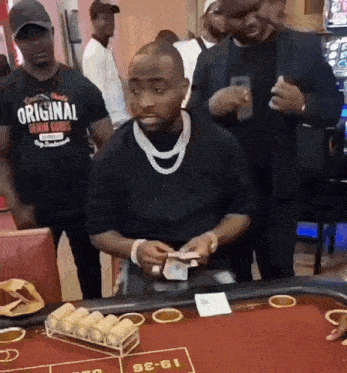 a man is sitting at a table with a t-shirt that says original