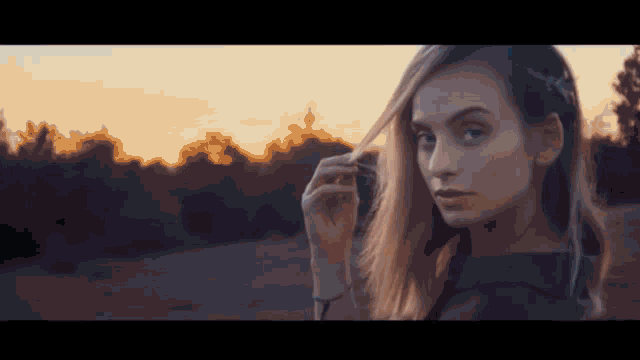 a close up of a woman 's face with the sun behind her