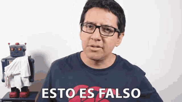 a man wearing glasses says " esto es falso " in front of a robot