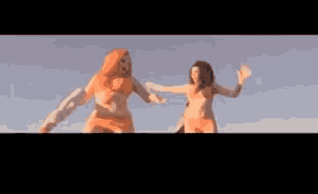 a woman with long red hair is singing into a microphone in front of a sunset .