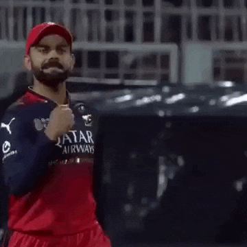 virat kohli is wearing a red and blue jersey and a red hat .