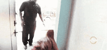 a man in a black shirt is standing in a doorway next to a woman with pink hair