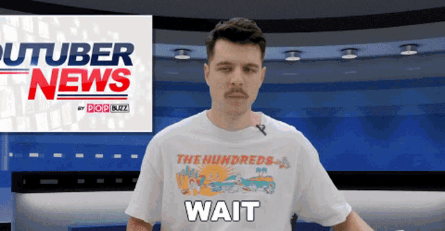 a man wearing a white shirt that says wait