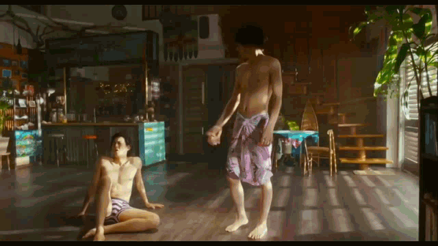 a shirtless man in purple shorts is holding a woman 's hand in a room