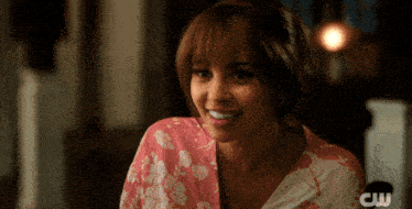 a woman wearing a pink and white floral shirt with cw written on the bottom right