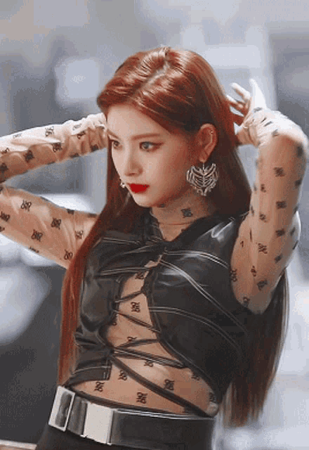 a woman with red hair is wearing a black top that says ' rr ' on it