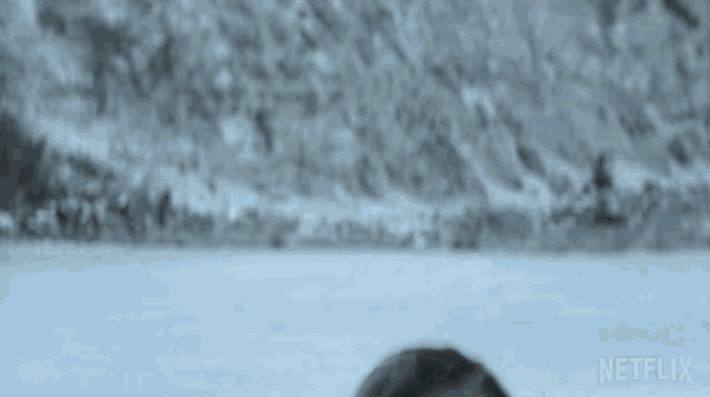 a blurred image of a person standing in the snow with a netflix logo in the corner