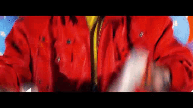 a close up of a person wearing a red jacket and a yellow shirt .