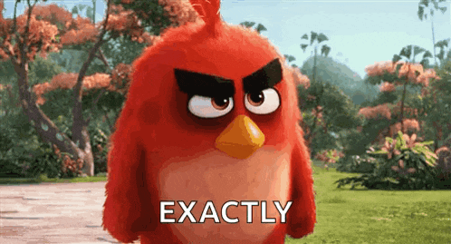 a red angry bird from the angry birds movie is standing in a grassy field .