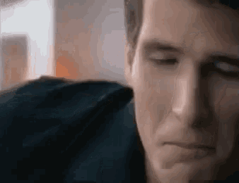 a close up of a man 's face with his eyes closed while sitting on a couch .