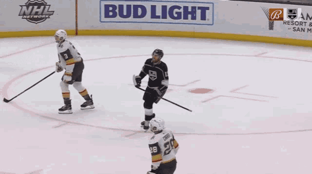 a hockey game is being played in front of an ad for bud light