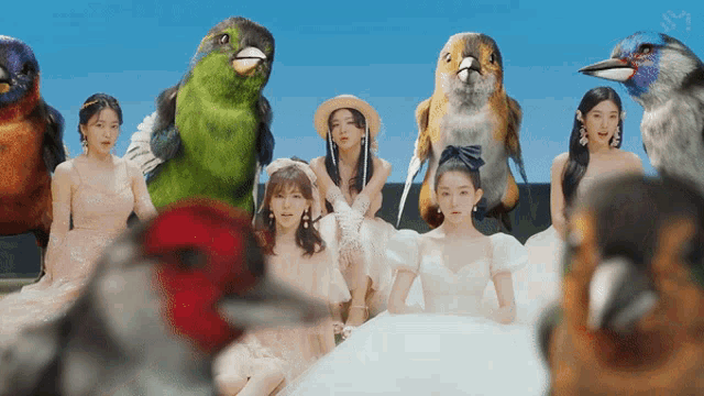 a group of women are surrounded by birds including a large green parrot