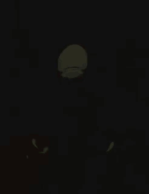 a person is standing in the dark with a glowing face in the dark .