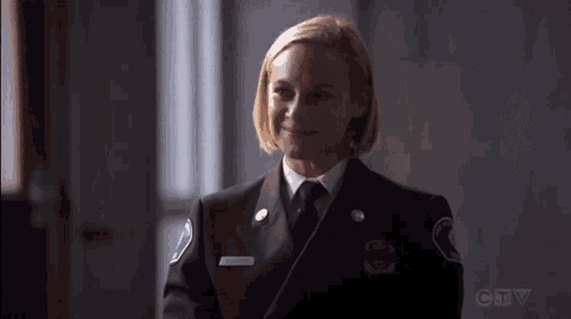 a woman in a firefighter uniform is smiling .