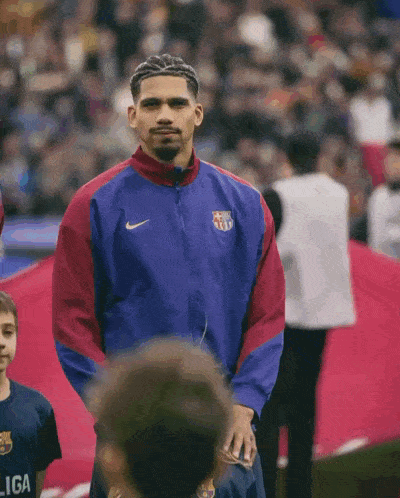 a man wearing a nike jacket stands in front of a crowd