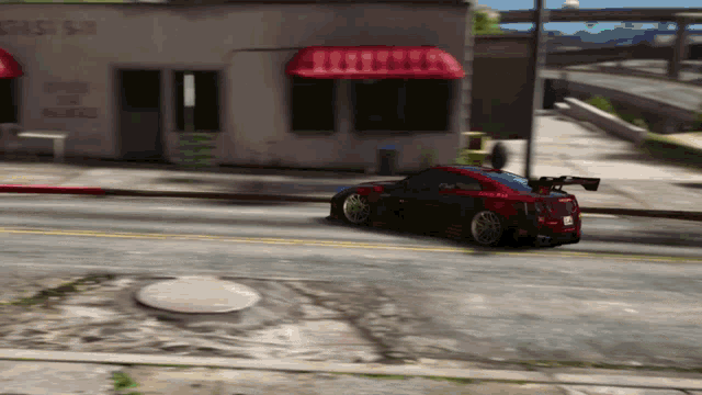 a red car is driving down a street in front of a building that says ' casa sa ' on it