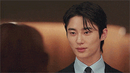 a man in a suit and tie is looking at another man .
