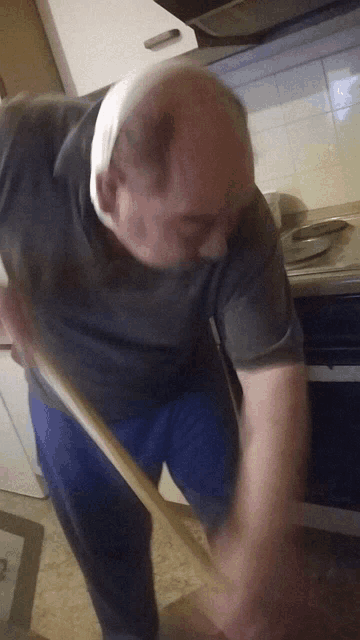 a man with a bandage on his head is using a broom