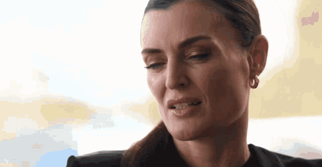 a close up of a woman 's face with a sad look on her face