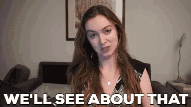 a woman with long hair is standing in front of a bed and says `` we 'll see about that '' .