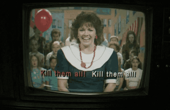 a television screen shows a woman standing in front of a crowd with the words kill them all on the screen
