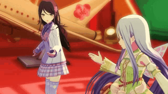 a couple of anime girls are standing next to each other on a red carpet .