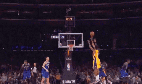 a basketball player with the number 8 on his jersey is jumping in the air with his arms outstretched .