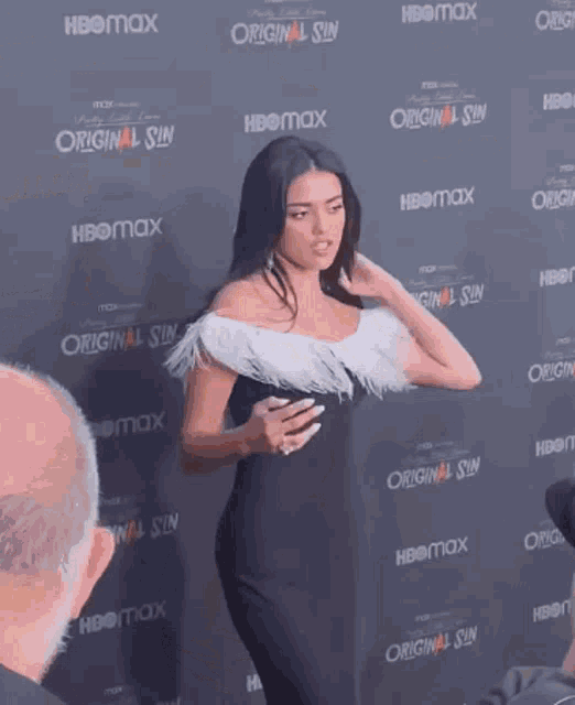 a woman is standing in front of a wall that says original sin