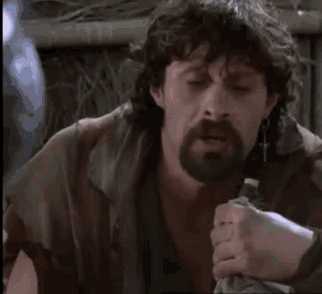 a man with a beard is holding a sword with the words a godhood is a sacred trust below him