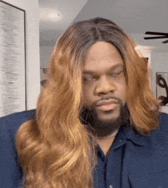 a man with long hair and a beard is making a face